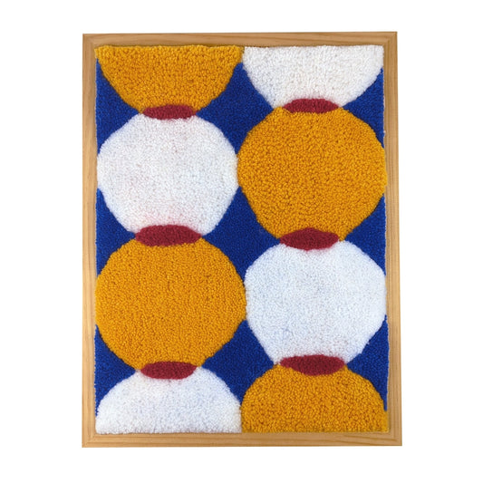 Tableau mural tufté en laine blanche, bleue, jaune et rouge représentant des formes géométriques ronde qui s'entrecroisent.