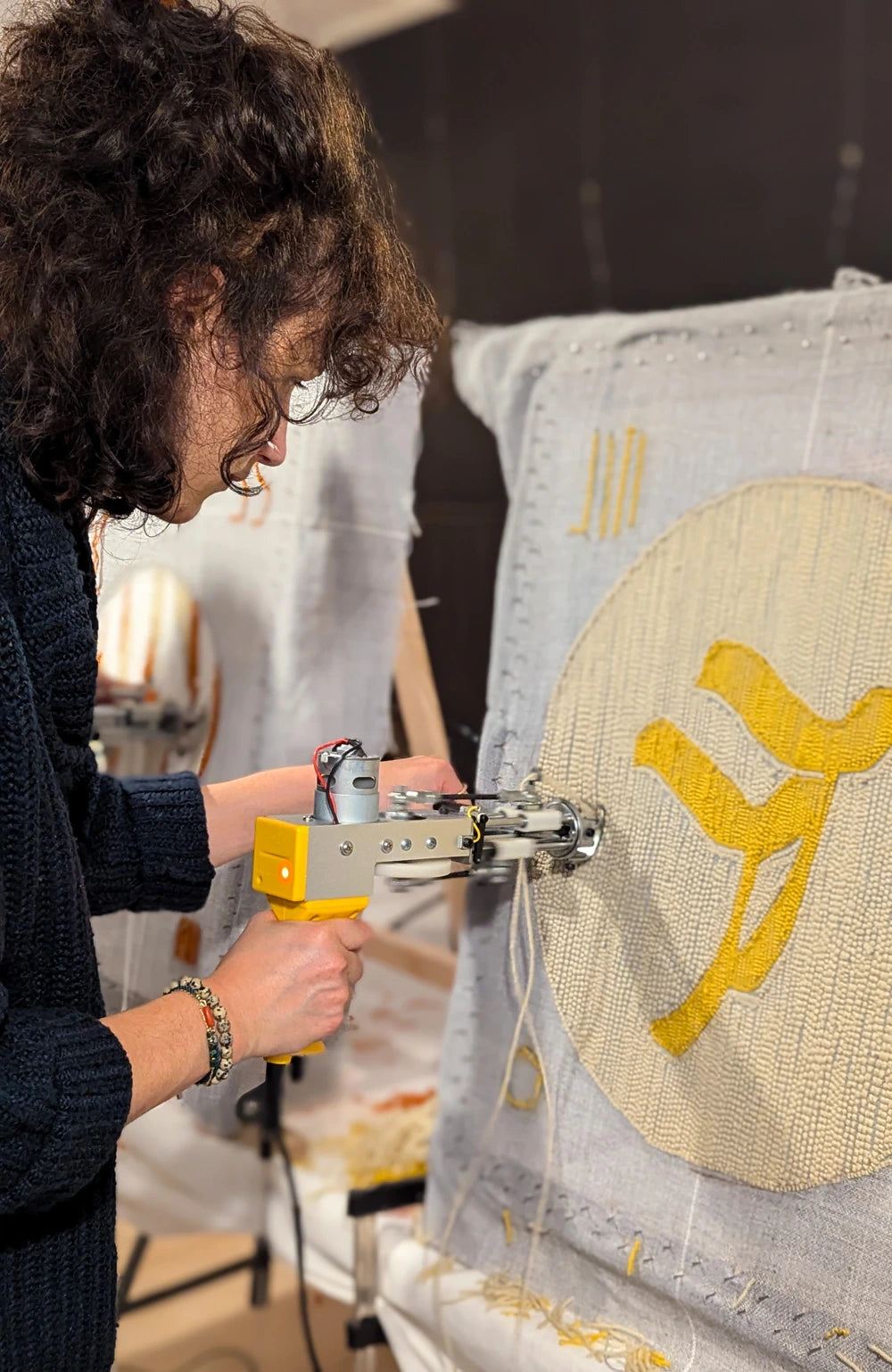 Femme qui réalise sont premier tapis avec la technique du Tufting