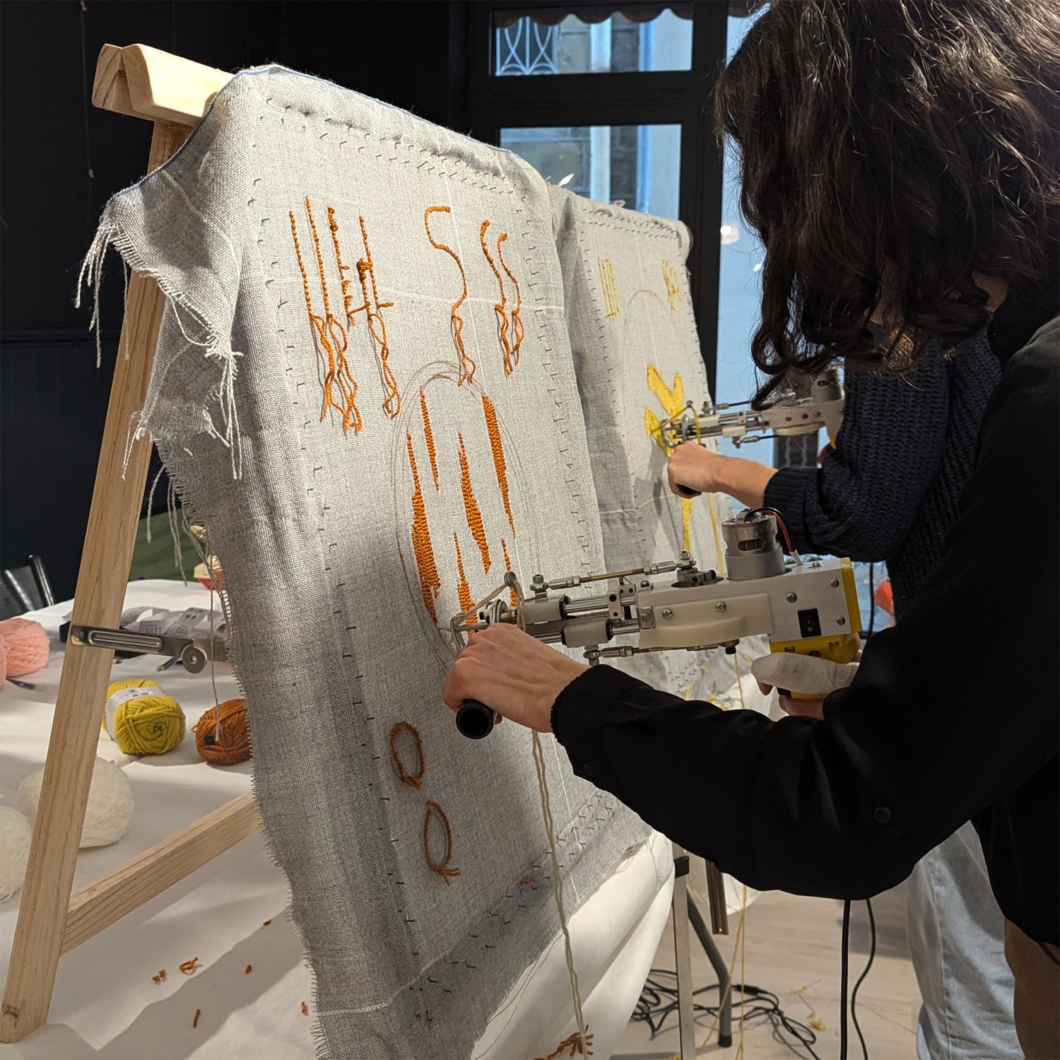 Élève d'un atelier tufting réalisant son tapis de 30cm