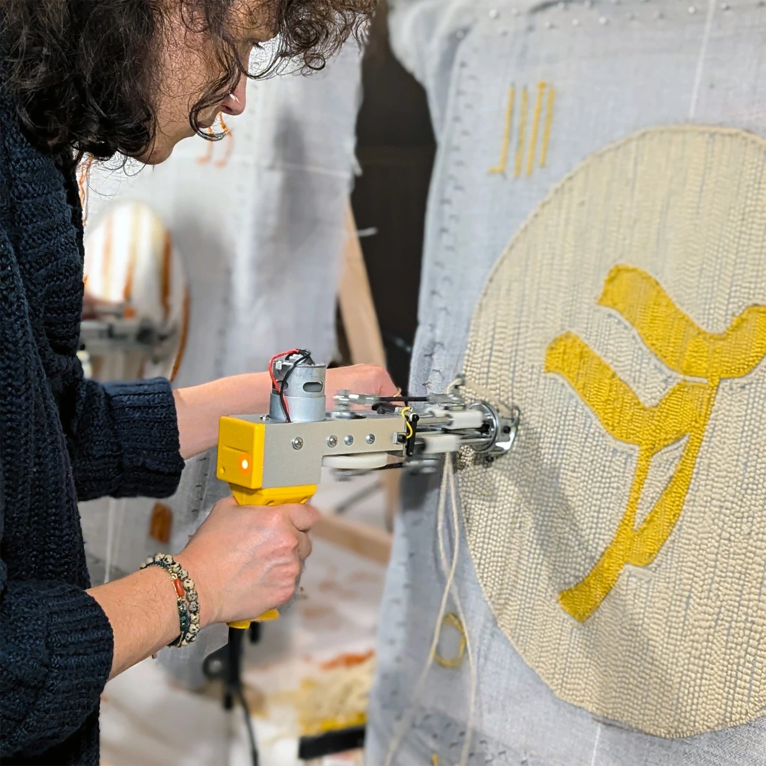 Femme réalisant sont tapis de 50cm lors d'un atelier tufting.